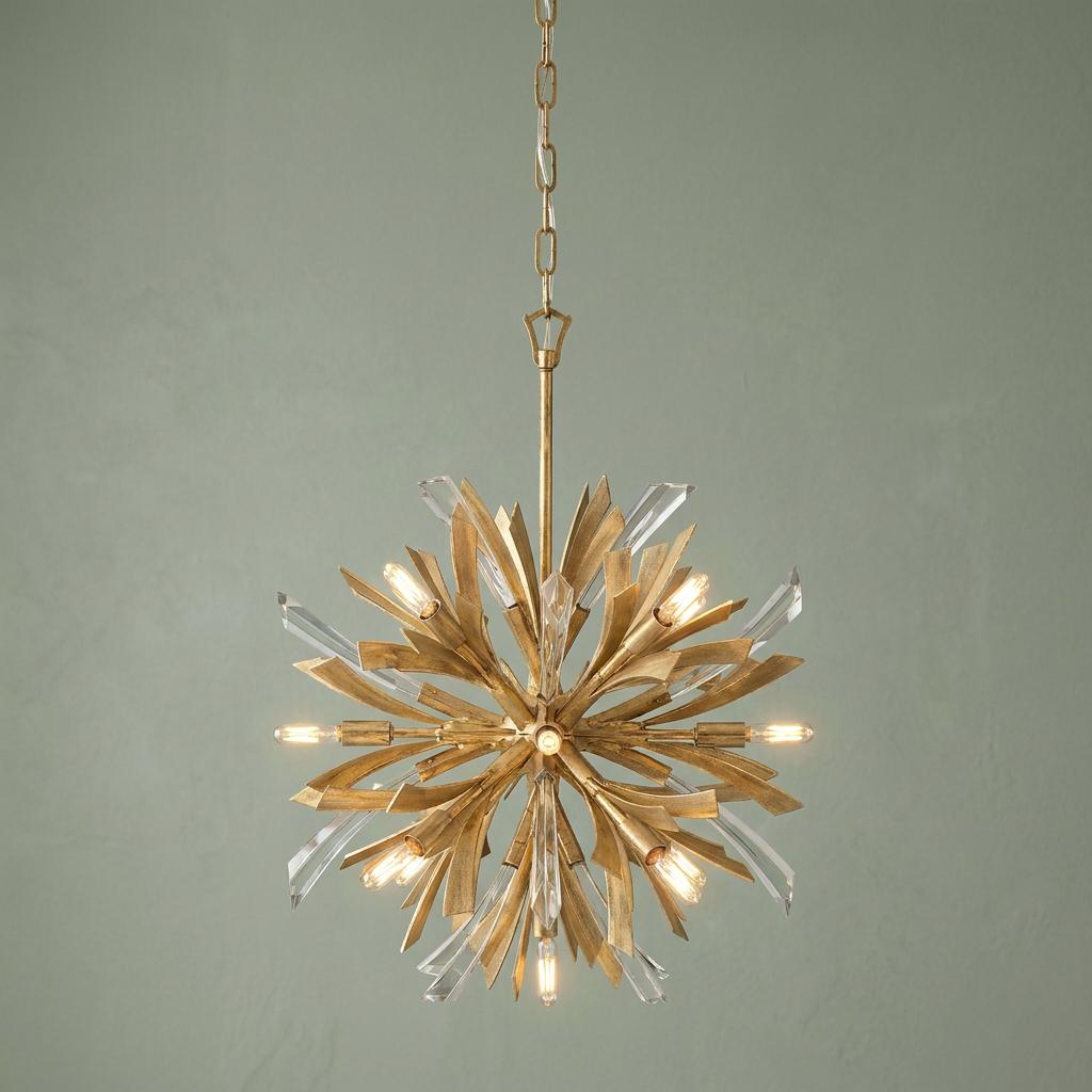 Vida 13-light gold pendant light with a sunburst design and crystal accents against a pale green wall.