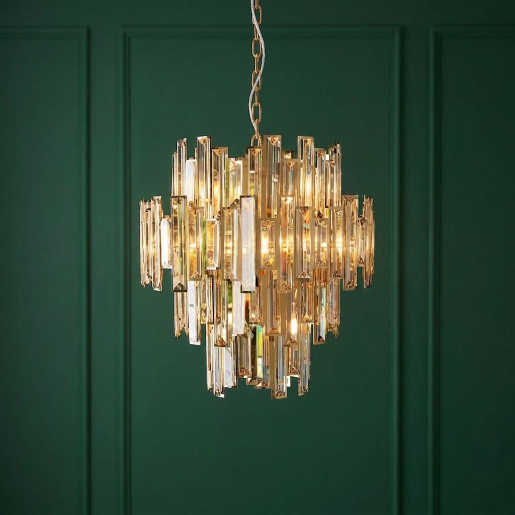 Viviana 12 light gold and champagne crystal tiered chandelier against a dark green panelled wall.