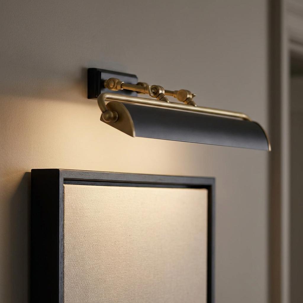 Winchfield brass and black picture light mounted above a framed canvas, emitting a warm downward glow.