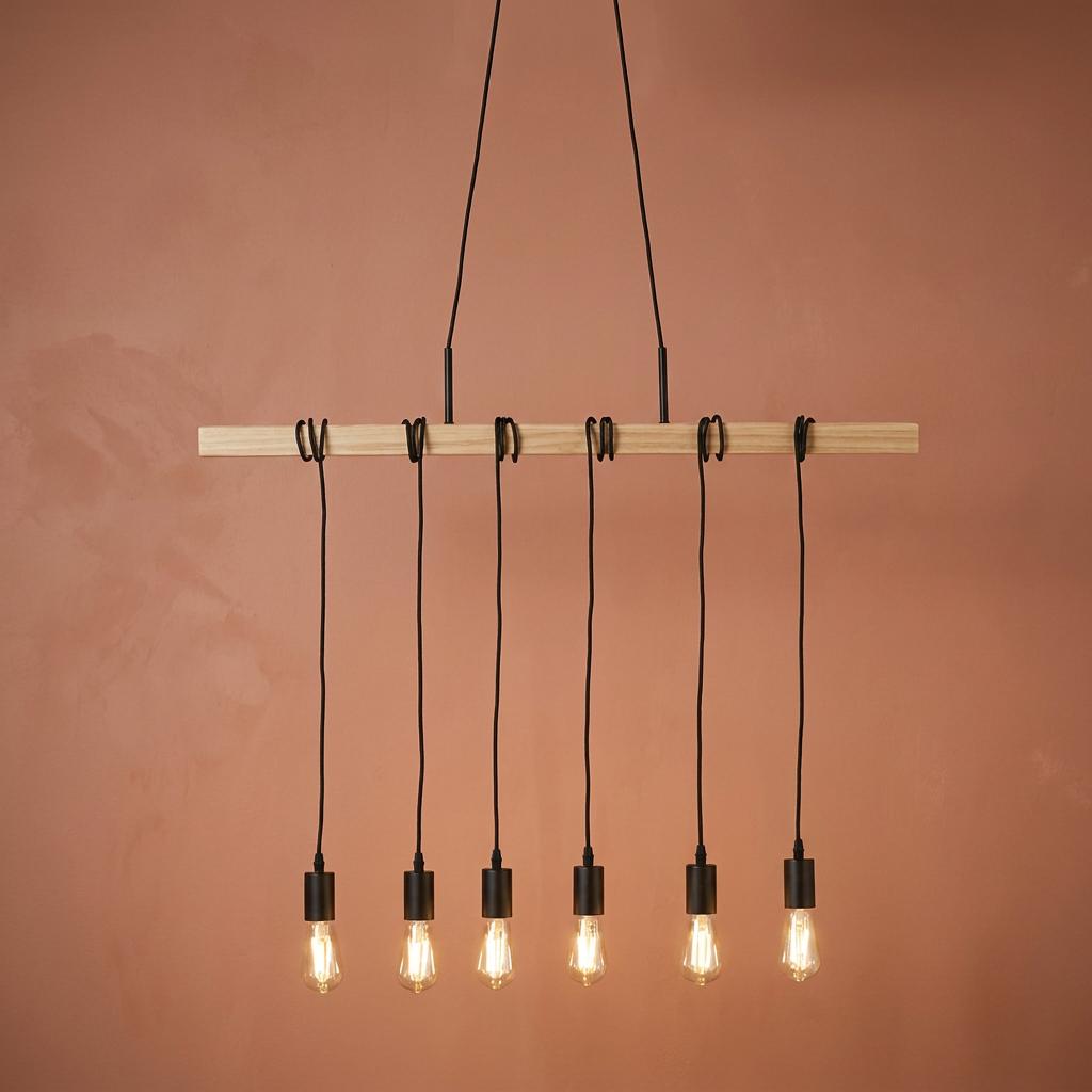 Six-light pendant with black cords wrapped around an ash wood beam against a terracotta wall.
