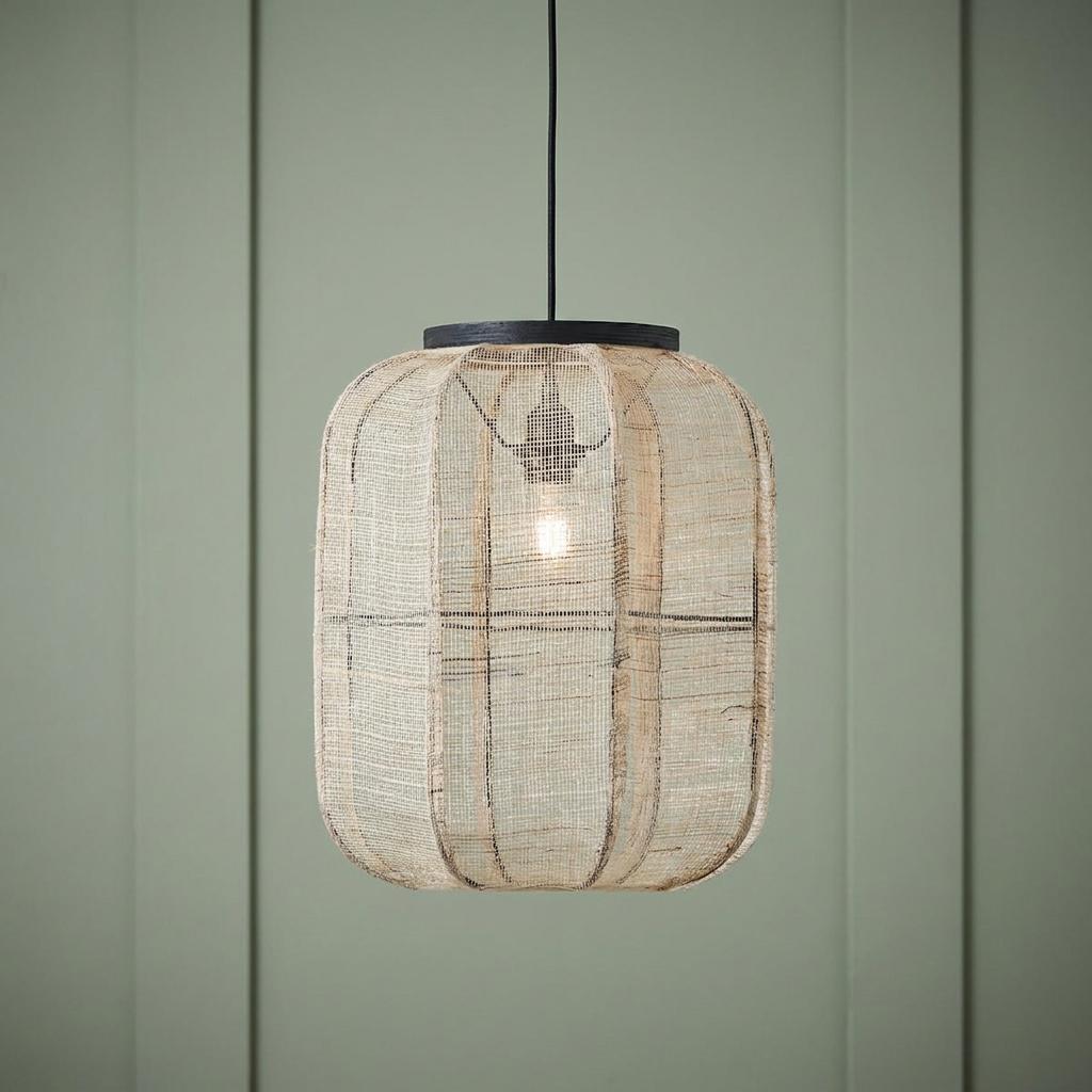 Zaire Natural Linen Adjustable Ceiling Pendant with a woven lantern shade hanging against a green paneled wall.