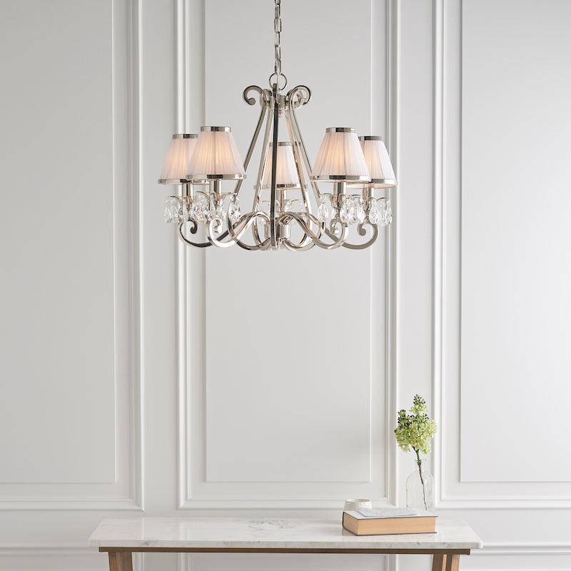 Oksana nickel chandelier 63515 white shades.  wide living room shot