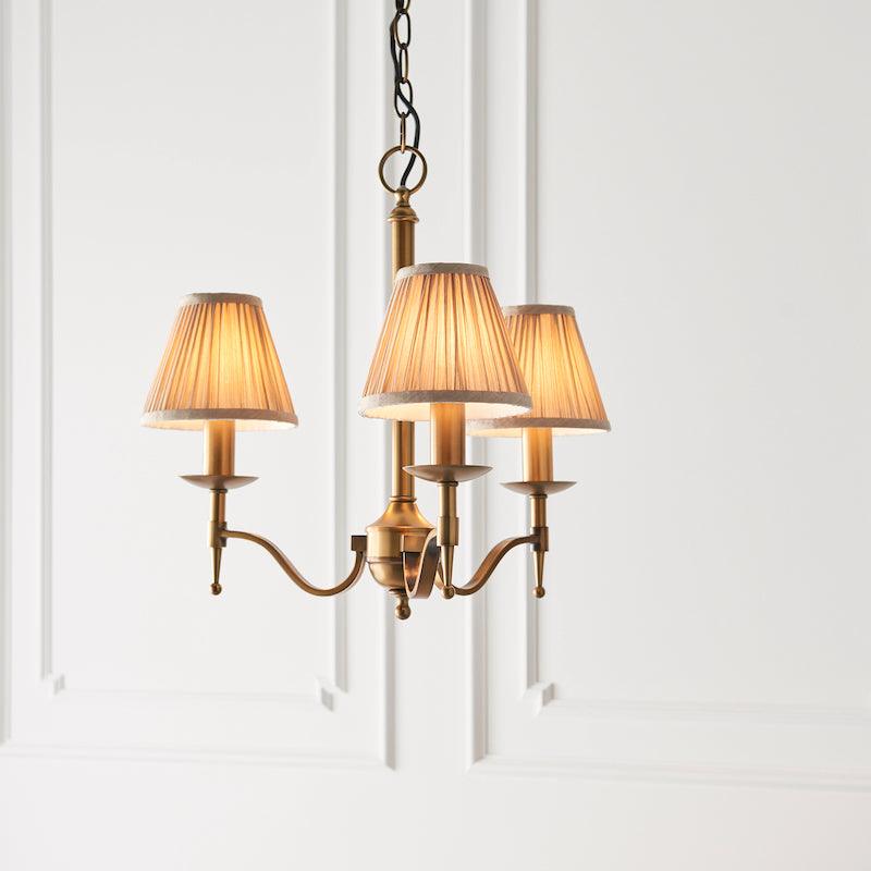 Traditional Ceiling Pendant Lights - Stanford 3 Light Antique Brass Chandelier With Beige Shades 63628 side living room shot