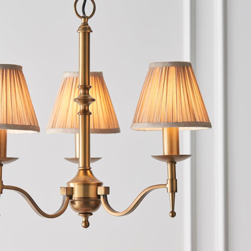 Traditional Ceiling Pendant Lights - Stanford 3 Light Antique Brass Chandelier With Beige Shades 63628 close living room shot